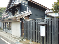 グレーの外壁と三角屋根で出来た2階建て建物の写真