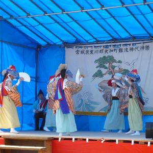 ステージ上で扇子を手に踊る、和服姿の演者達の写真