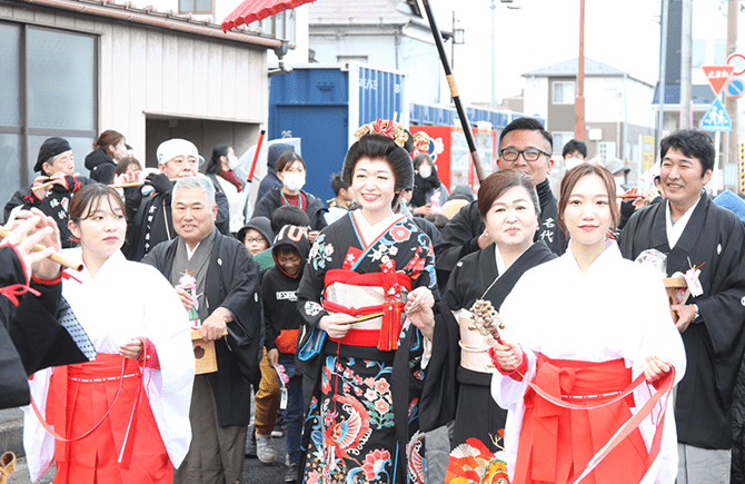 着物を着た女性を囲んだお祭りの画像