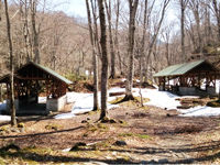 屋根付きの施設が複数設置されたキャンプ場の写真