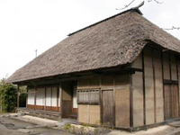 資料館になっている藁葺き屋根の古風な建物の写真