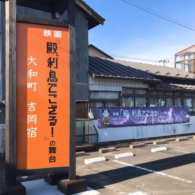 「映画 殿、利息でござる！の舞台」と書かれた看板の立っている吉岡宿の一角の写真