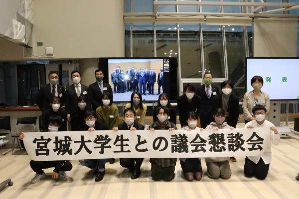 宮城大学生との議会懇談会と書かれた横断幕を掲げている集合写真