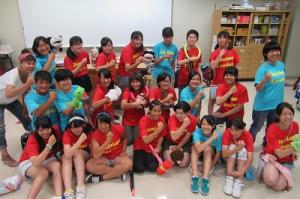 赤や青などのTシャツを着た子どもたちが集まってポーズを決めている写真