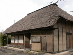 茅葺屋根で木造の建物を斜め正面から撮影した写真