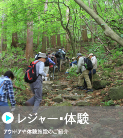 「アウトドアや体験施設のご紹介」木々の中登山をしている人々の写真（レジャー・体験のページへリンク）