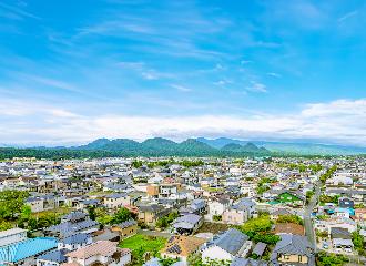 住宅街が広がり遠くに七ツ森が見える画像