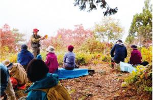 笹倉山の国見崎展望台でお弁当を食べる参加者の写真