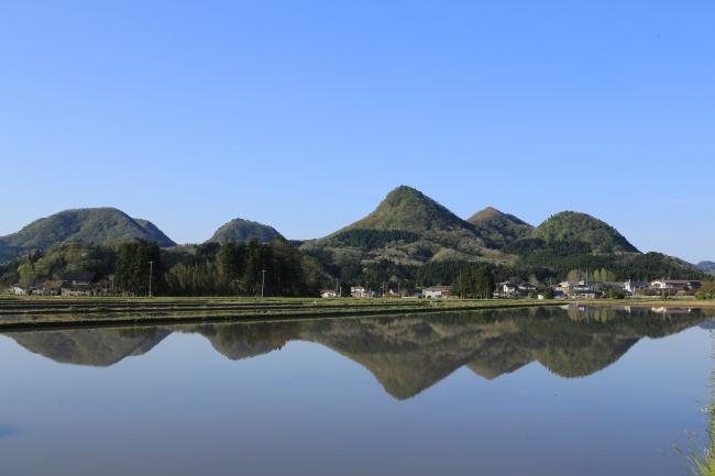 水面に反射している青空と山々の写真